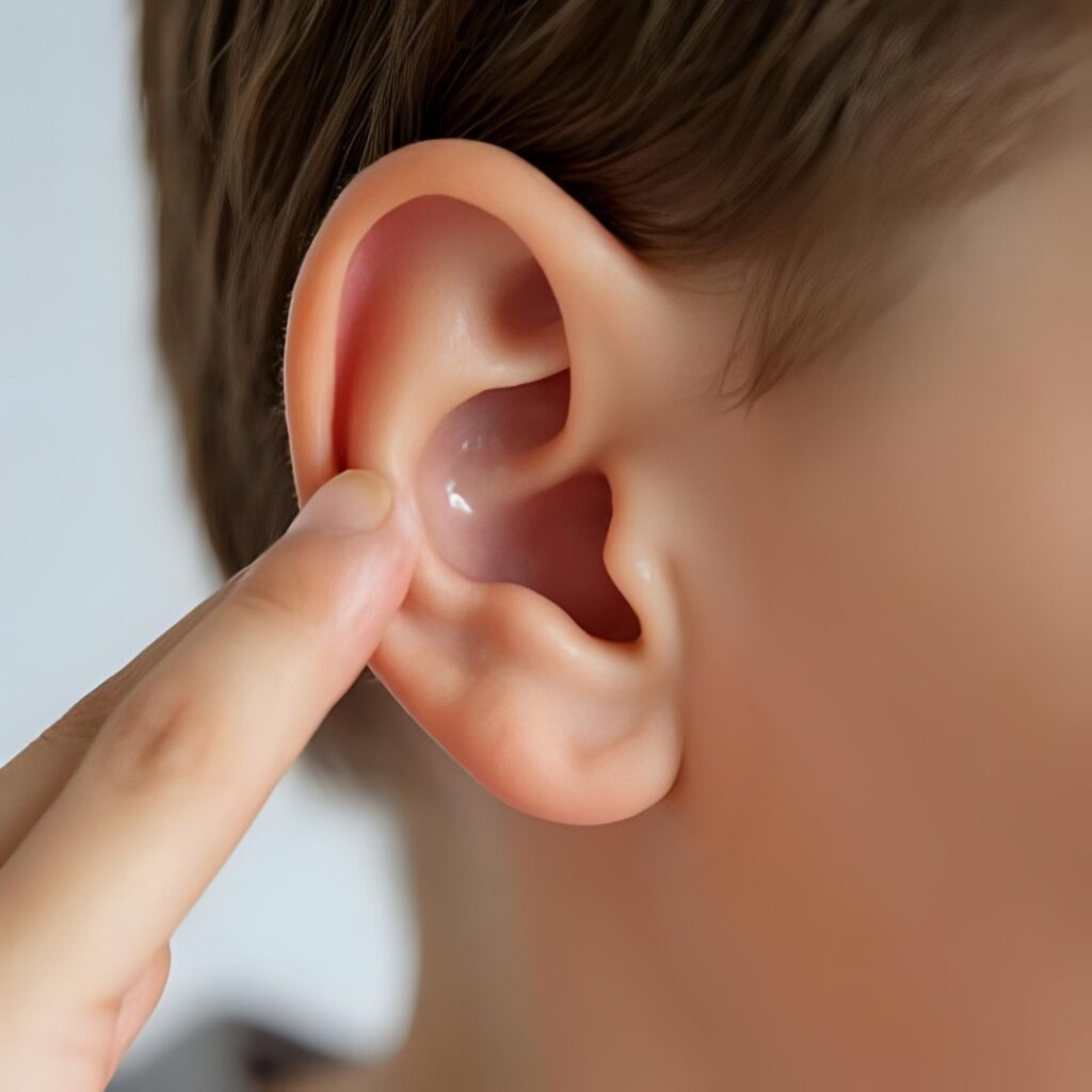 child with ear wax using finger to remove