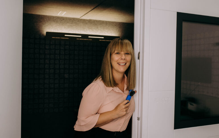 Audiologist standing in soundproof booth.